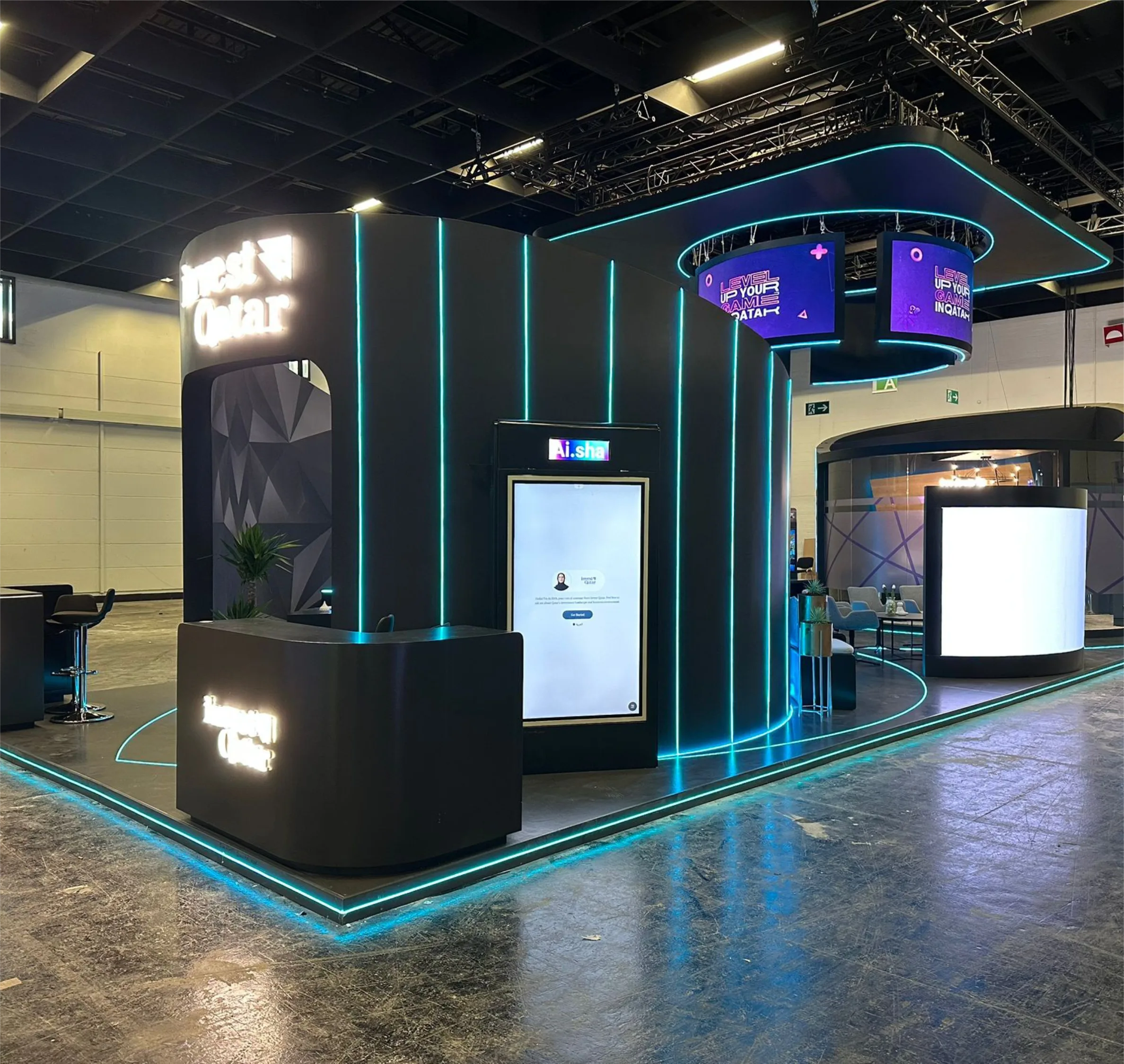 Invest Qatar standı: fasetli siyah yüzeyler üzerinde turkuaz LED hatlar, dokunmatik kiosk ekranları ve asma dairesel ekran halkası